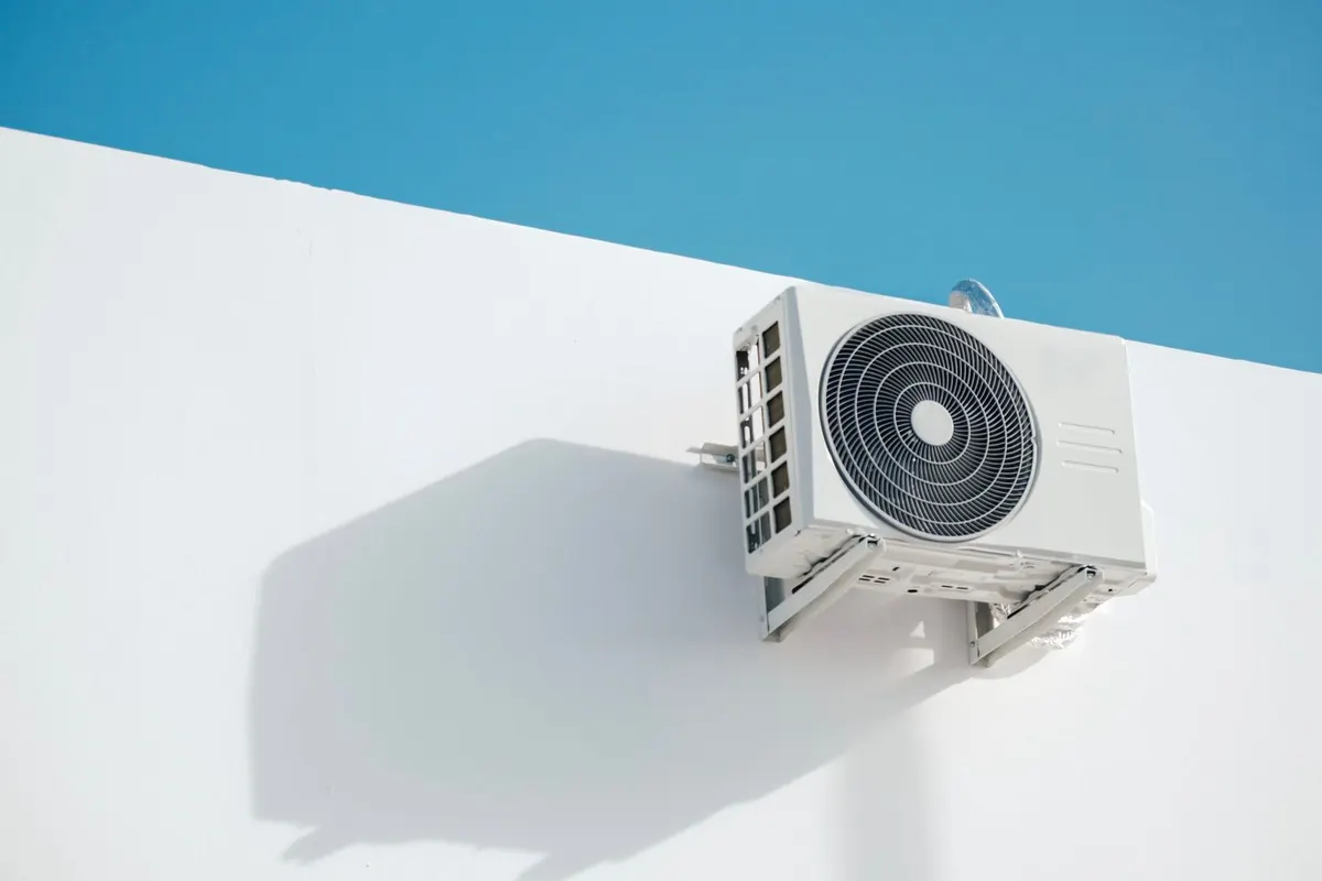 New white outdoor condensing unit on a clean wall